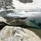 61 Le pareti rocciose si immergono nelle gelide acque del Lago del Vallone in disgelo.JPG